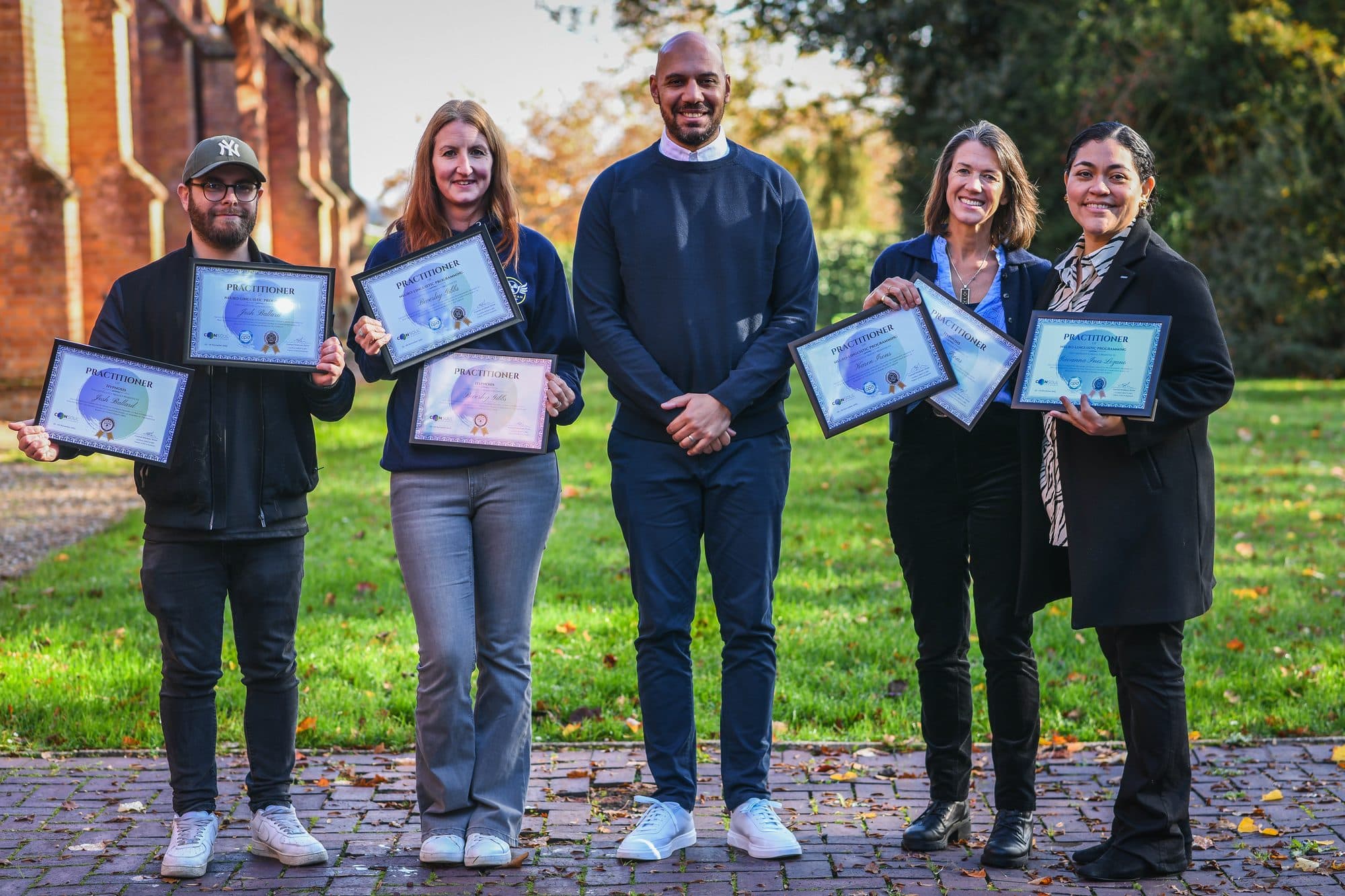 A Consoul cohort holding their NLP Practitioner certificates with trainer Conrad Mepham-Stone